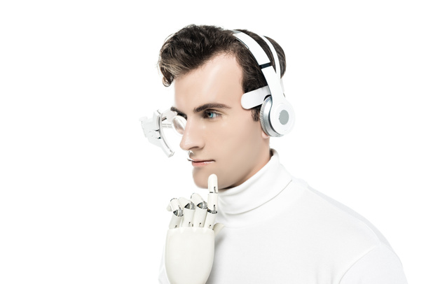 Cyborg with headphones, digital eye lens and artificial hand looking away isolated on white - Фото, изображение