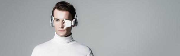 Cyborg σε ψηφιακό φακό ματιών και ακουστικά που απομονώνονται σε γκρι με αντίγραφο χώρου, banner - Φωτογραφία, εικόνα