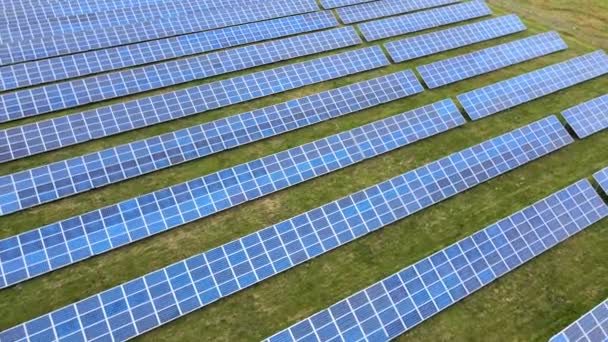 緑のフィールド上の太陽光発電所の空中ビュー。クリーンな生態エネルギーを生産するための電気パネル. - 映像、動画