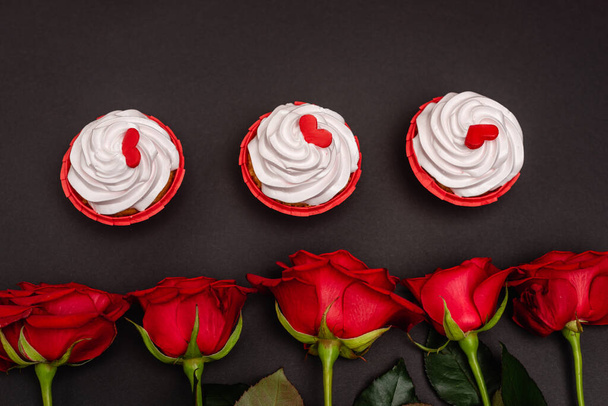 top view of roses and cupcakes isolated on black - Фото, зображення