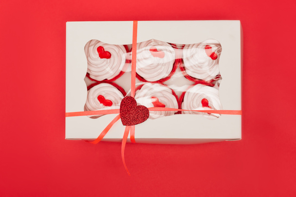 Ansicht der Schachtel mit Valentines Cupcakes isoliert auf rot - Foto, Bild