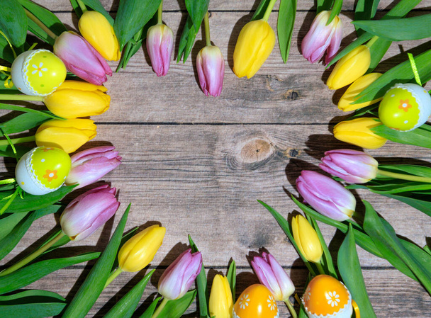 un tavolo in legno con tulipani gialli e viola - Foto, immagini