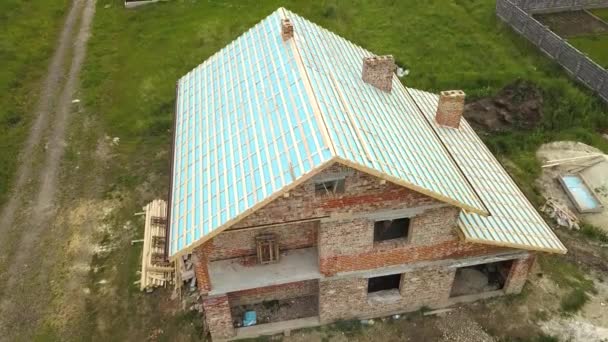 Вид с воздуха на кирпичный дом с деревянным каркасом крыши в стадии строительства. - Кадры, видео