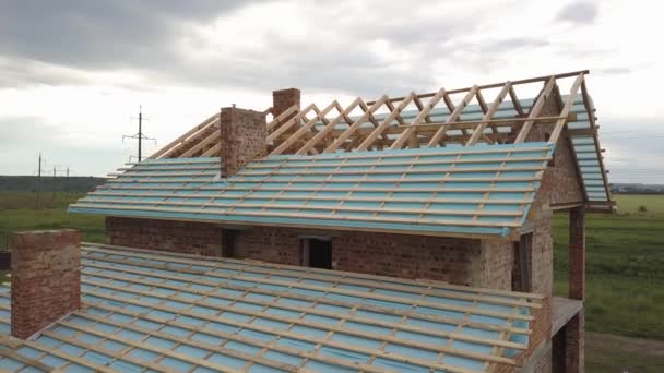 Letecký pohled na cihlový dům s dřevěným střešním rámem ve výstavbě. - Záběry, video