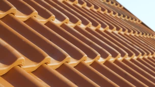 Pokrywające się rzędy żółtych dachówek ceramicznych pokrywających dach budynku mieszkalnego. - Materiał filmowy, wideo