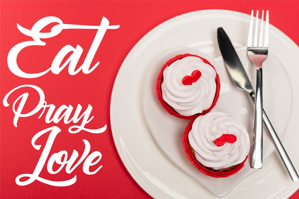 top view of cupcakes on plate with cutlery near eat pray love lettering on red background - Фото, изображение