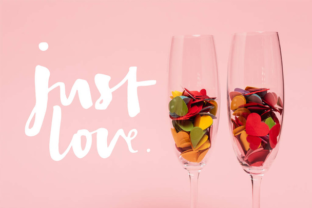 corações coloridos em copos de champanhe perto apenas amor lettering em rosa - Foto, Imagem