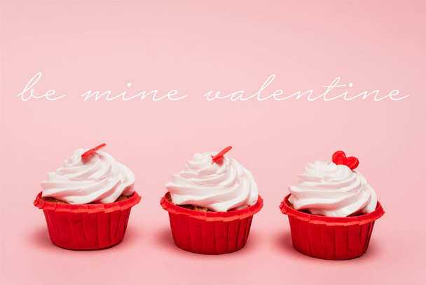 valentines cupcakes with red hearts near be mine valentine lettering on pink background - Фото, зображення