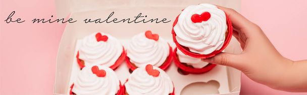 cropped view of woman holding valentines cupcake near box and be mine valentine  lettering on pink background, banner - 写真・画像