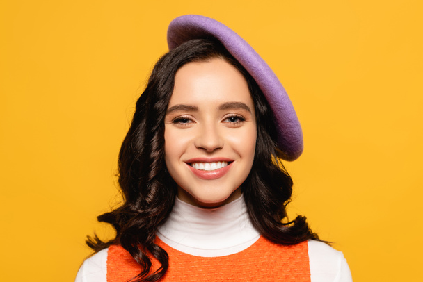Portrait of smiling brunette woman in beret looking at camera isolated on yellow - Fotoğraf, Görsel
