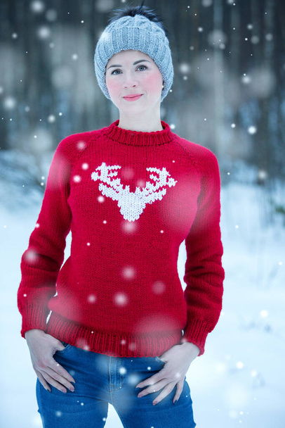 Молодая красивая женщина в красном свитере с оленем - Фото, изображение