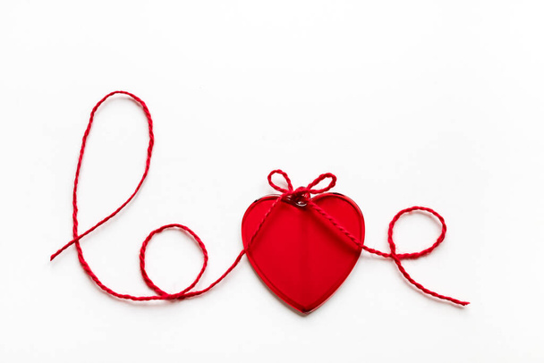 Valentine's day concept. Red heart and word love made from woolen rope on white background with copy space - Foto, immagini