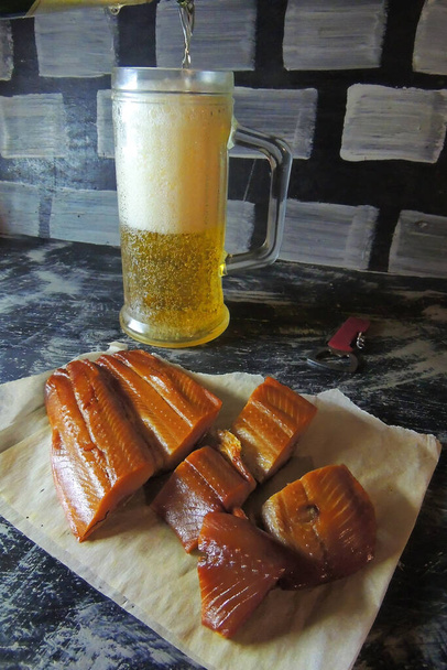 スモークフィッシュ、クリスピークラッカー、塩と軽ビールのマグカップ - 写真・画像