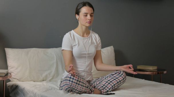 ベッドで瞑想する美しい若い女性,ヨガ - 写真・画像