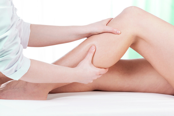 Hands massaging female leg - Fotoğraf, Görsel