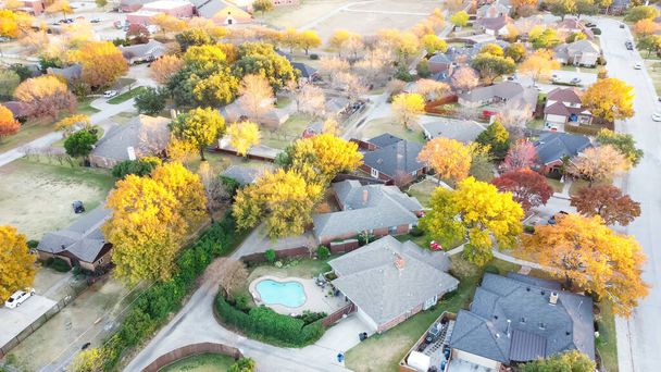 Parkseitige Wohngegend mit typischen Einfamilienhäusern von oben, umgeben von farbenfrohem Herbstlaub in Coppell, Texas, Amerika bei Sonnenuntergang - Foto, Bild