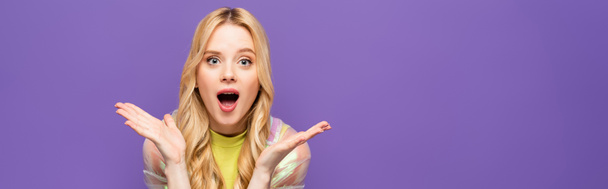 shocked blonde young woman in colorful outfit isolated on purple, banner - Foto, Imagen