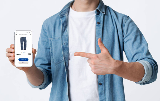 Mann zeigt Handy bei Online-Bekleidungsgeschäft - Foto, Bild