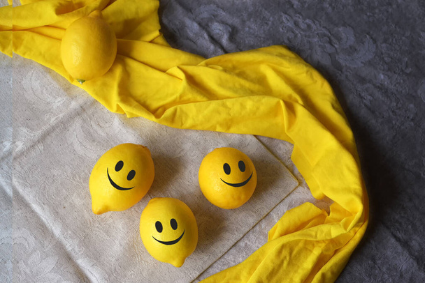 Pozitív érzelmek. Sárga citrom vicces arccal az asztalon.  - Fotó, kép