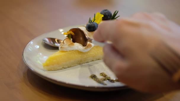 Muž jí kousky lahodného citrónového tvarohového koláče se šlehačkou na bílém talíři - Záběry, video
