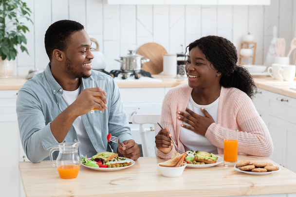 jong gelukkig zwart paar met gezond ontbijt samen in keuken thuis - Foto, afbeelding