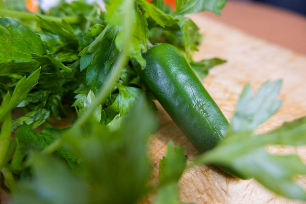 Groene chili peper en koriander op een houten tafel - Foto, afbeelding