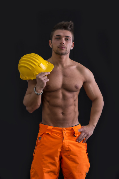 Muscular young construction worker shirtless with hardhat - 写真・画像