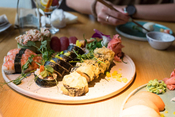 Ein Teller Sushi. Verschiedene Arten japanischer Küche. Leckeres Essen im Restaurant während des Treffens. - Foto, Bild
