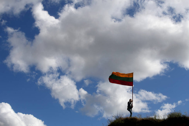 Joven mujer feliz con bandera lituana, fondo del cielo - Foto, imagen