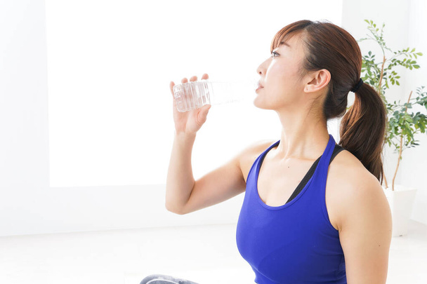 Young woman sports wear drinking water - Foto, Bild