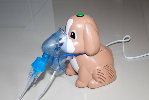 Een inhalator in de vorm van een hondje. Geschikt voor volwassenen en kinderen. Compressor vernevelaar. - Foto, afbeelding
