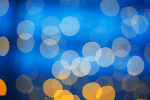 Yellow lights garland bokeh on blue background, New Year and Christmas concept - Foto, Imagem