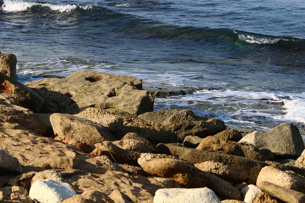 большие камни и снаряды на берегу Средиземного моря на севере Израиля  - Фото, изображение