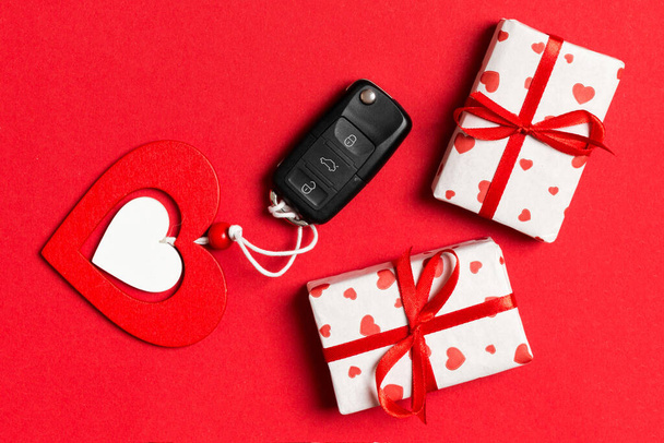 Vue de dessus de la clé de voiture, boîtes-cadeaux et coeur de jouet sur fond coloré. Concept Saint-Valentin avec espace de copie. - Photo, image