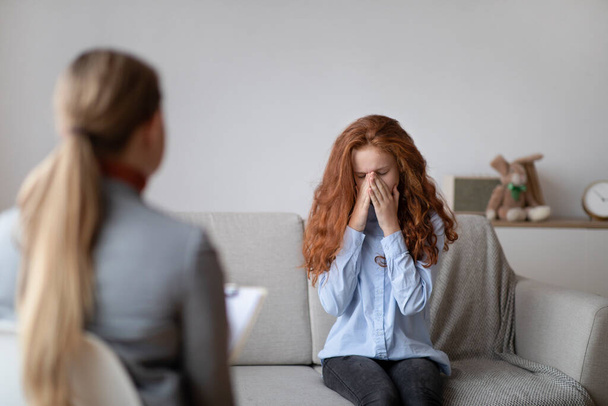 Child Psychologist. Worried sad teen girl crying during consultation - Photo, Image