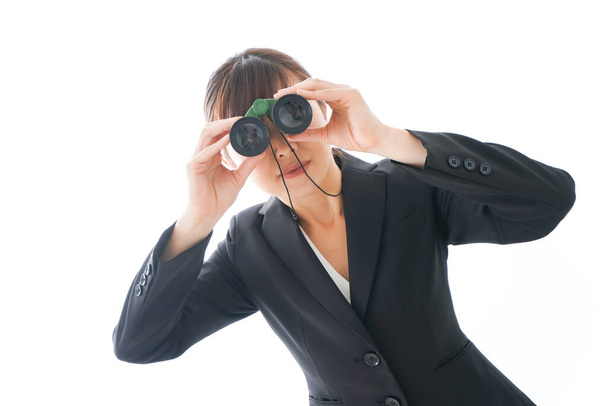 Audit and Compliance consulting concept, Young businesswoman looking through binoculars  - Foto, Imagen