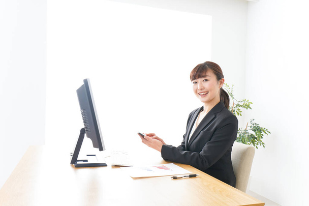 Femme d'affaires travaillant avec le sourire au bureau - Photo, image
