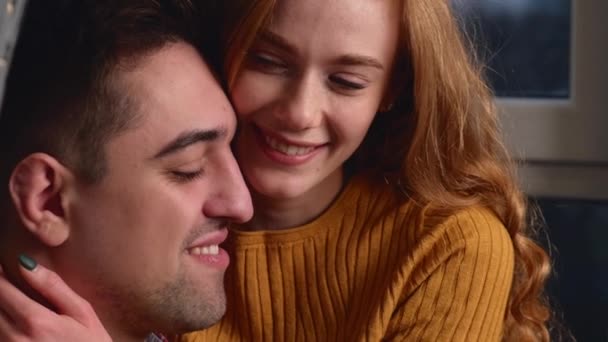 Liebenswertes Paar sitzt am Valentinstag zusammen und lächelt einander umarmend an - Filmmaterial, Video