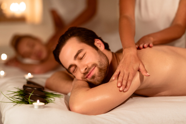 Ehemann und ehefrau genießen massage und pflanzliche aromatherapie liegend drinnen - Foto, Bild