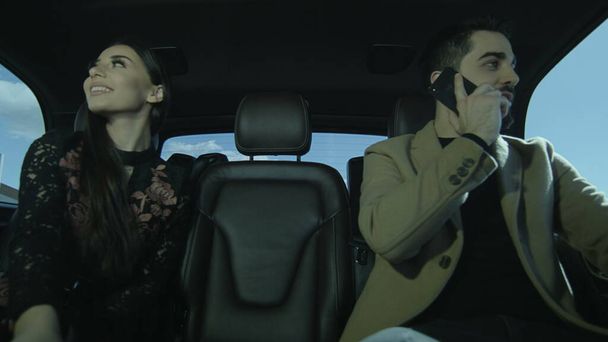 Ο νεαρός και μια νεαρή κοπέλα κάθονται στο αυτοκίνητο. Μιλούσαν μεταξύ τους και θαύμαζαν. Ζευγάρι ερωτευμένο στο αυτοκίνητο. Φωτογραφία, ακόμα, εικόνα. - Φωτογραφία, εικόνα