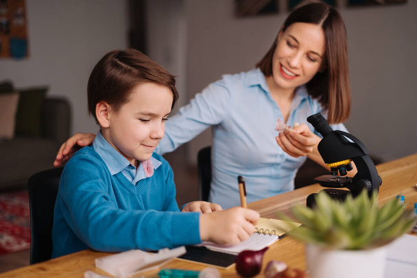 Thuis leren, vrouw en jongen studeren aan tafel - Foto, afbeelding
