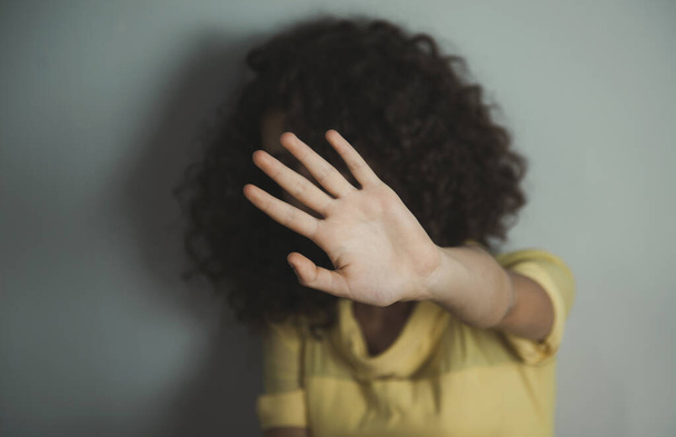 young sad woman hand stop sign on grey background - Фото, зображення