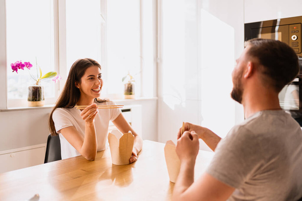 Smiling man and woman having lunch together at home - Photo, Image