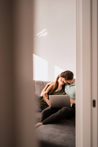 Homem e mulher sentados no sofá com um laptop - Foto, Imagem