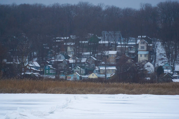 Huizen van een vissersdorp aan de oevers van het bevroren Voronezh stuwmeer in de winter - Foto, afbeelding