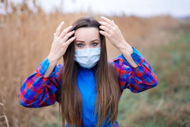 piękna dziewczyna w kratę sukienka z maską medyczną - Zdjęcie, obraz
