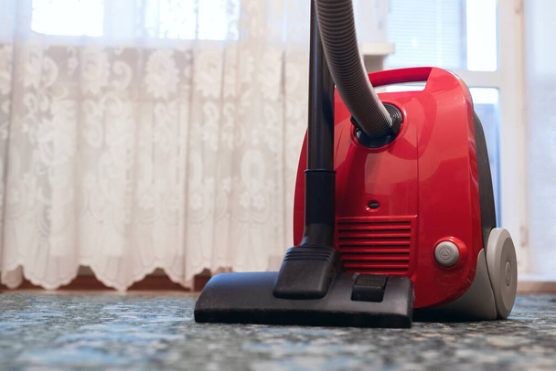 Vacuum cleaner on the floor in the living room close up. - Фото, изображение
