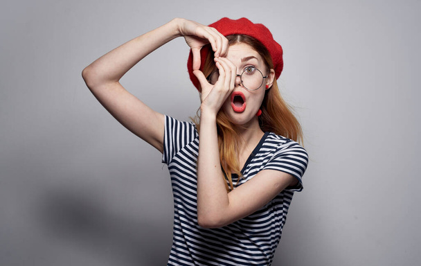 Эмоциональная женщина в очках и в полосатой футболке жестикулирует руками - Фото, изображение