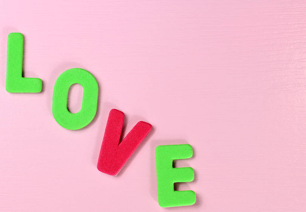 Love, amor, te amo Schriftzug auf rosa Hintergrund, gelb rot blau grün Buchstaben auf Romantik Sankt Valentin, Hochzeit, Geburtstag, Datum, Datingkarte - Foto, Bild