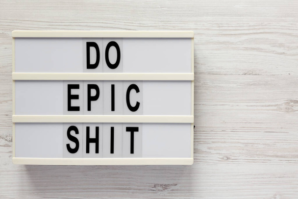 'Do epic shit' on a lightbox on a white wooden background, top view. Flat lay, overhead, from above. Space for text. - Foto, Imagen